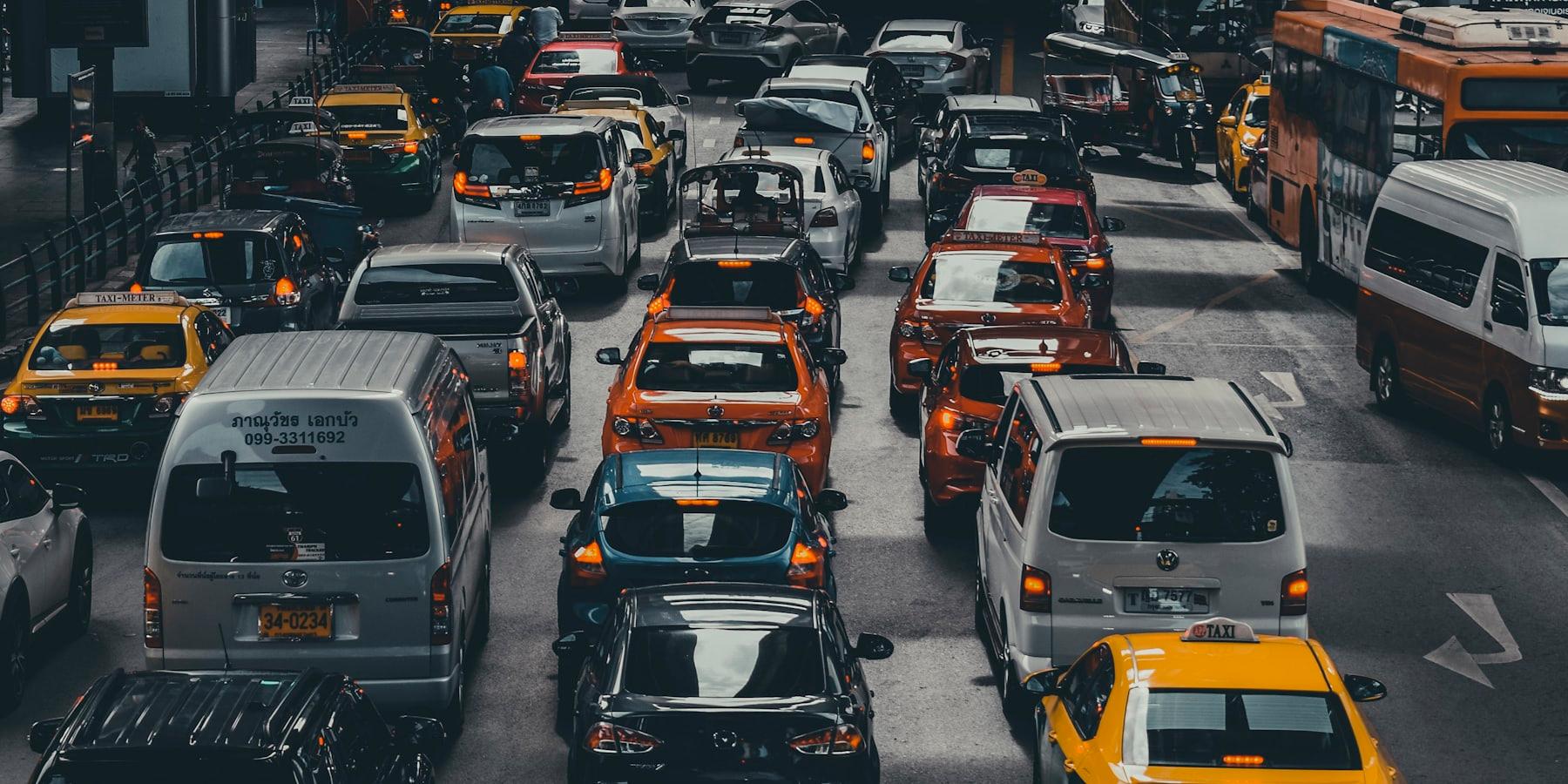 Assorted vehicles moving along a city road in daylight